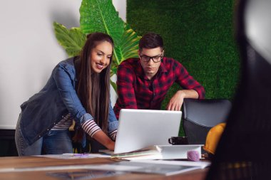 Bir proje üzerinde birlikte çalışan genç erkek ve dişi mimarlar. 