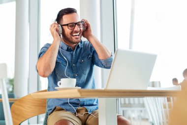 Onun kulaklık ile bir kafede üzerinde yakışıklı öğrenci.