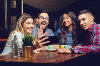 Portre seyir akıllı telefon kafede otururken neşeli genç arkadaşlar. -Görüntü