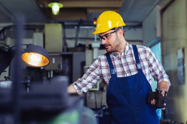 Turner çalışan bir fabrikada bir Torna makinesi üzerinde çalışıyor 