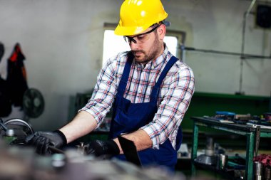 Turner çalışan bir fabrikada bir Torna makinesi üzerinde çalışıyor