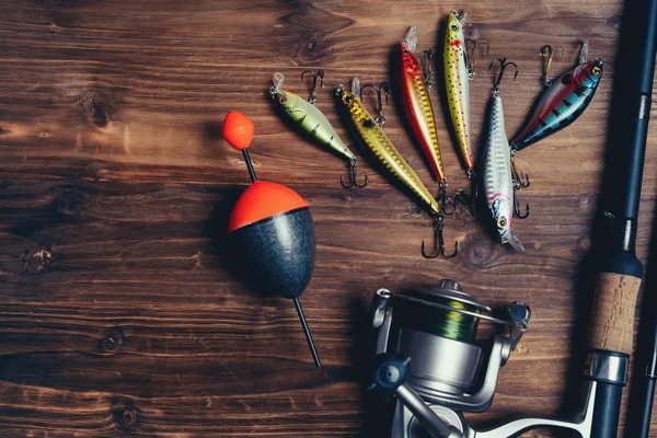 Fishing Feeder and Reel.Fishing Tackle Background.Fishing Feeder- Hooks and  Lures on Darken Wooden Background. Stock Photo - Image of colorful, reel:  153443488