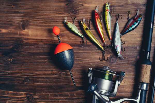 Fishing tackle on the wooden background