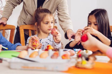Küçük kızlar Paskalya günü için yumurta boyar