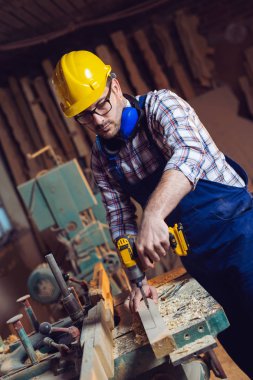 Marangoz tezgah üzerinde ahşap plaka bir delik sondaj 