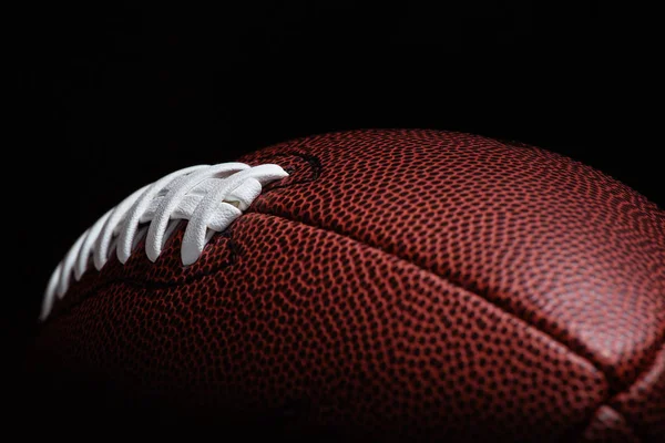 American football on dark background.