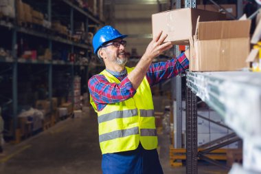 Müşteriye teslim için omuzda ambalaj tutan depo işçisi