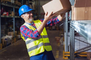 Karton kutu yerleştiren depo işçisi