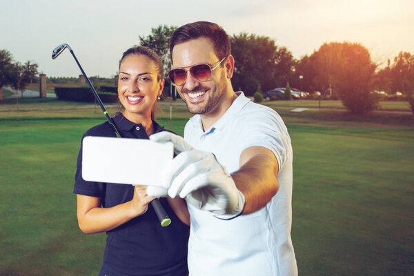 Young couple making selfie on a golf course