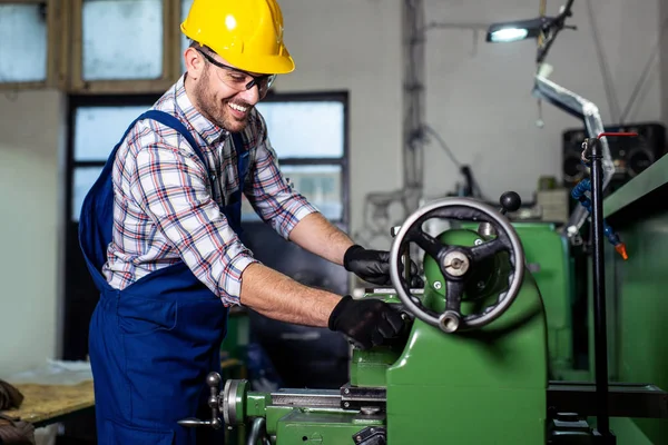 Turner çalışan bir fabrikada bir Torna makinesi üzerinde çalışıyor.