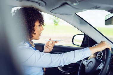 iş kadını arabada oturur ve telefonla konuşuyor