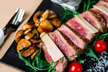 Dilimlenmiş ızgara sığır barbekü biftek ve domates ve arugula ile salata