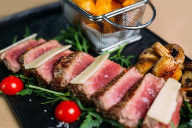 Dilimlenmiş ızgara sığır barbekü biftek ve domates ve arugula ile salata