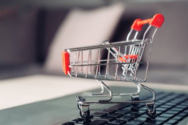 Masada dizüstü bilgisayar ile alışveriş sepeti, online alışveriş konsepti.