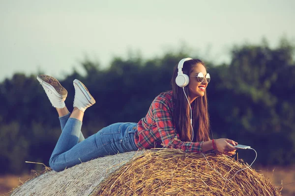 Beautiful Girl Sitting Haystack Listening Music Enjoying Sunset — Stock Photo, Image