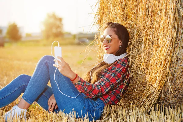 Mädchen Das Mit Eingeschaltetem Headset Weizenfeld Sitzt Sie Lehnt Sich — Stockfoto