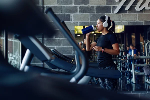 Schöne Mädchen Joggen Auf Dem Laufband Und Trinken Einen Shaker — Stockfoto