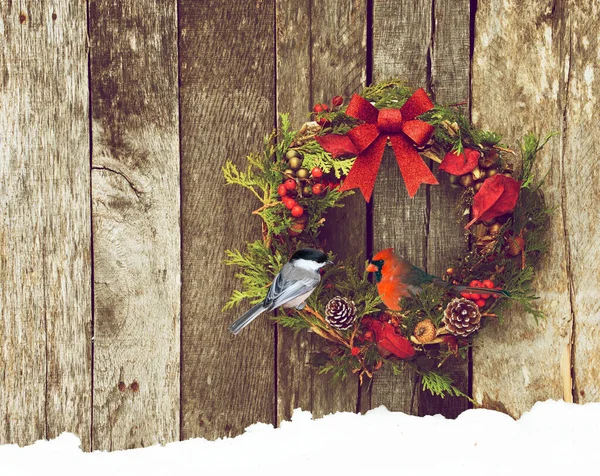 美しい男性と自然の装飾が施されたクリスマスの花輪北枢機卿は コピースペースと素朴な木製の壁にかかって かわいいひよこが倒れた ストックフォト