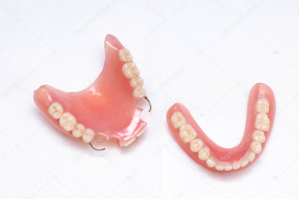 Dentures lie on a white background, upper and lower jaw, top view. Dental prosthetics