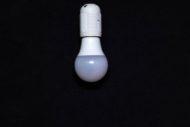 Siyah arka planda asılı LED lamba. Elektrik Kaydetme Konsepti.