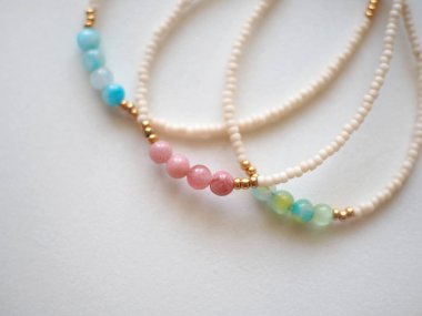 Bilezik ve Kolye : Beyaz arka planda izole edilmiş karışık boncuklar : Bulanık, yumuşak odak