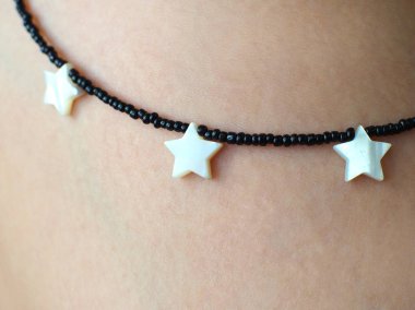 İnsan derisinde beyaz yıldız şekilli kolye: bulanık, yumuşak odaklı