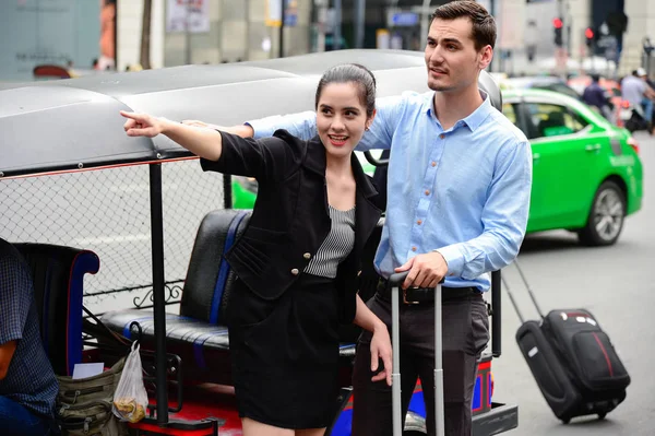 Turistas caucásicos sonríen y se paran cerca de Tuk Tuk en la calle. hey están emocionados por su primer viaje en Bangkok, Tailandia . — Foto de Stock