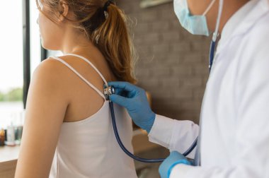 Doktor elinde bir stetoskop tutup hastanedeki kadın hastanın sırtına koymuş. Sağlık Kavramı, Tıbbi tedavi , muayene