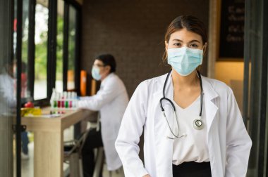 stetoskop ayakta ve hastanede kameraya bakan kadın doktor.