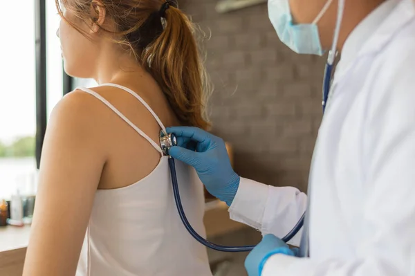 Doktor elinde bir stetoskop tutup hastanedeki kadın hastanın sırtına koymuş. Sağlık Kavramı, Tıbbi tedavi , muayene