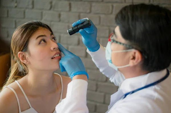 Doktor beyaz ceket klinikte hastanın gözleri için bir el feneri parlar. Sağlık, tıbbi tedavi kavramı
