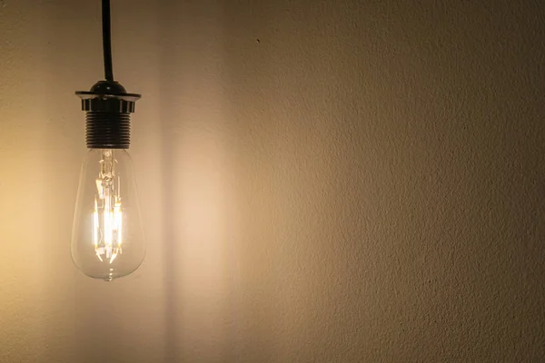 Lâmpada brilhante pendurar na parede e espaço de cópia para texto, conceito de ideia — Fotografia de Stock