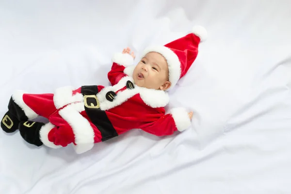 Pequeno bebê vestindo vermelho Papai Noel traje dormir no tapete de pele branca. Conceito de celebra Natal e feriados de Ano Novo . — Fotografia de Stock