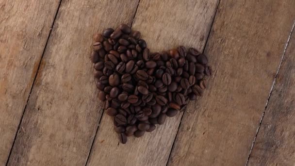 Kaffeebohnen Schaffen Herz Auf Holztisch — Stockvideo