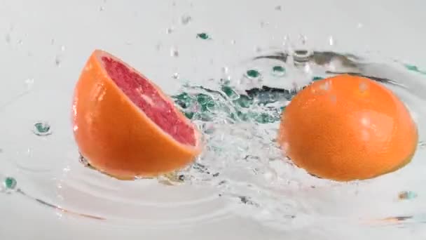 Geschnittene Grapefruit Fällt Ins Wasser — Stockvideo