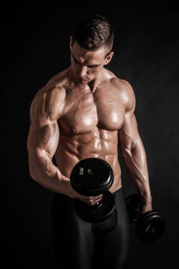 Atletik gömleksiz genç erkek fitness modeli dumbbells ile