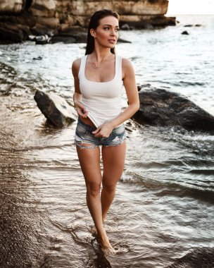 Genç güzel kadın bir sahilde poz