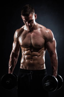 Atletik gömleksiz genç erkek fitness modeli dumbbells ile