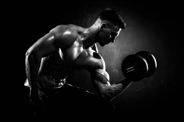 Atletik gömleksiz genç erkek fitness modeli egzersizleri yapar