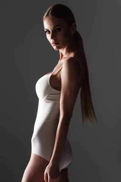 Piękne blond kobieta w bieliźnie pozowanie na szaro — Zdjęcie stockowe