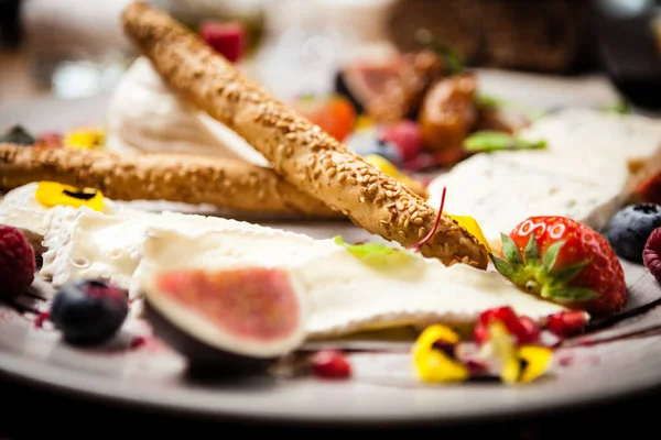 Bandeja de queso para dos: crema de queso de cabra, gorgonzola, camembert, grissini y mermelada de higo. Delicioso primer plano de comida tradicional italiana saludable servido para el almuerzo en el restaurante de cocina gourmet moderna — Foto de Stock