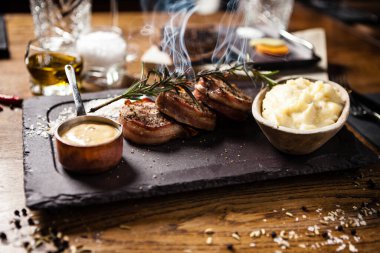 Patates püresi, pastırma ve hardal soslu domuz filetosu ve tüten biberiye. Modern yemek gurme restoranında öğle yemeği olarak sunulan lezzetli, sağlıklı geleneksel ızgara et yemeği..