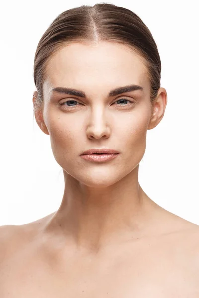 Conceito de beleza natural e cuidados com a pele. Retrato de belo modelo feminino com rosto limpo isolado no fundo branco. Mulher jovem mostra pele sensível saudável depois de usar cosméticos e maquiagem — Fotografia de Stock