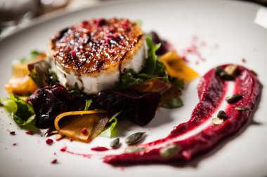 Izgara keçi peyniri salatası turşulu pancar reçeli, kızılcık reçeli, balkabağı tohumları lezzetli Akdeniz geleneksel vejetaryen yemekleri modern mutfak gurme restoranında öğle yemeğinde servis edilir.