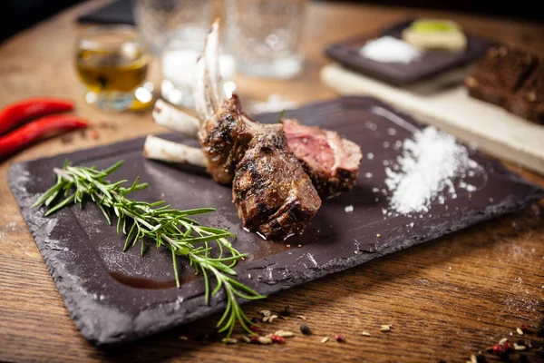 Grilled lamb chops served with a branch of rosemary — Stock Photo, Image