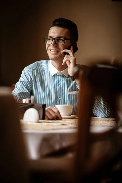 Lgbtqコミュニティライフスタイルのコンセプト 若い同性愛者の男が昔ながらの街のカフェのテーブルに座っています 昼食をしながら電話でハンサムなゲイの男性実業家の話 — ストック写真