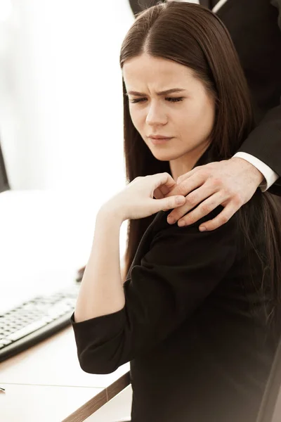 Sexual harassment at work. Male businessman puts hand on annoyed female assistant shoulder at workplace showing inappropriat behaviour. Two people man and woman conflict relations in modern office — Stock Photo, Image