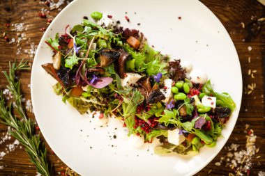 Taze vejetaryen salatası. Avokado, kuskus, kavun, portobello, soya fasulyesi, beyaz tabakta tofu. Lezzetli, sağlıklı, karışık sebzeler yakın plan yemekler modern mutfak gurme restoranında öğle yemeği için servis edilir.