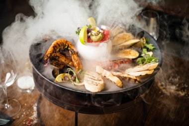 2-4 kişi için deniz ürünleri tabağı. Ahtapot, mavi midye, pişmiş yeşil midye, ızgara kaplan karidesi, ton balığı. Lezzetli deniz ürünleri modern gurme restoranında öğle yemeğinde servis edilir..