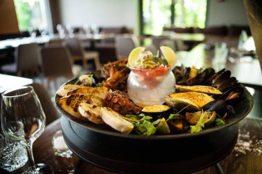 2-4 kişi için deniz ürünleri tabağı. Ahtapot, mavi midye, pişmiş yeşil midye, ızgara kaplan karidesi, ton balığı. Lezzetli deniz ürünleri modern gurme restoranında öğle yemeğinde servis edilir.